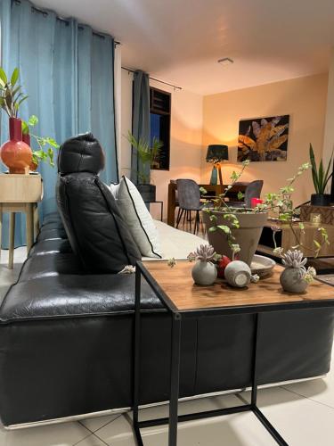 a black leather couch in a living room with a table at VILLA FRUIT A PAIN T3 in Cayenne