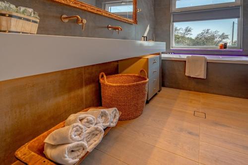 a bathroom with a sink and a basket on the floor at Semeli Art House 2 in EFL