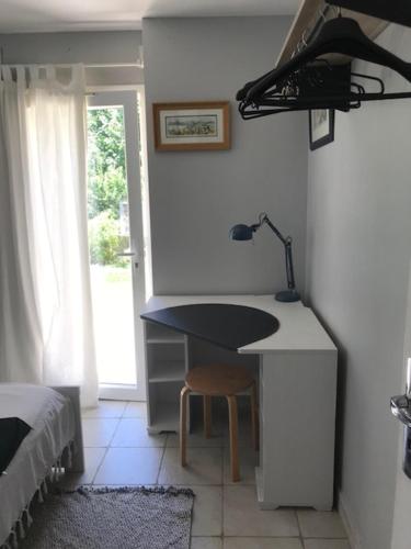 Cette chambre comprend un bureau avec une lampe et un lit. dans l'établissement Rez de jardin de villa avec piscine proche mer, à Toulon