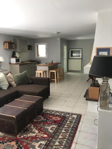 un salon avec un canapé et une cuisine dans l'établissement Rez de jardin de villa avec piscine proche mer, à Toulon