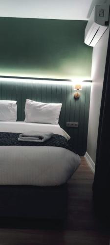 a bedroom with a bed with a green wall at OTTO X Hotel in Kavaklıdere