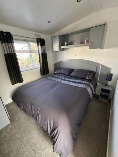 a bedroom with a large bed and a window at Happy Hilda in Selsey