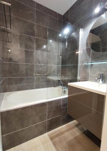 une salle de bain avec une baignoire et un lavabo dans l'établissement Hesperie studio, à Chamalières