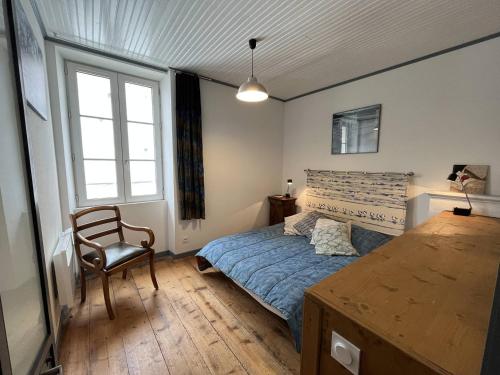 a bedroom with a bed and a chair and a table at Mais 4 pièces Oléron 6 couchages SAINT GEORGES D'OLERON SGO000-607 in Saint-Georges-dʼOléron