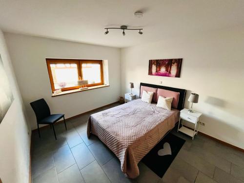 a bedroom with a bed and a chair and a window at Kinderparadies Alt Lüxem in Wittlich