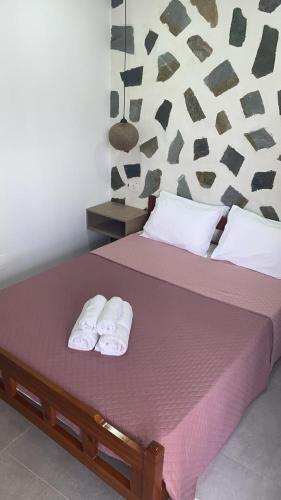 a bedroom with a bed with two towels on it at Harmonia Himara in Himare