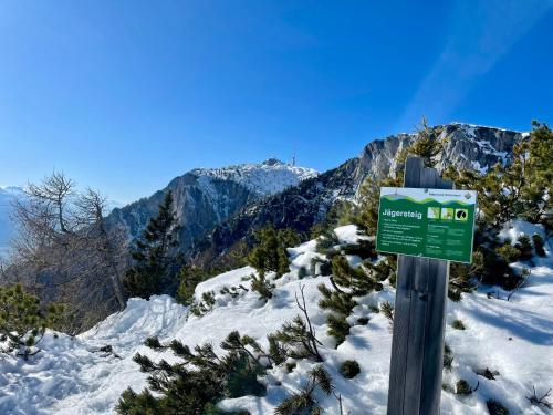 a green sign on a snow covered mountain at Sweet Mountain Home in Bad Bleiberg
