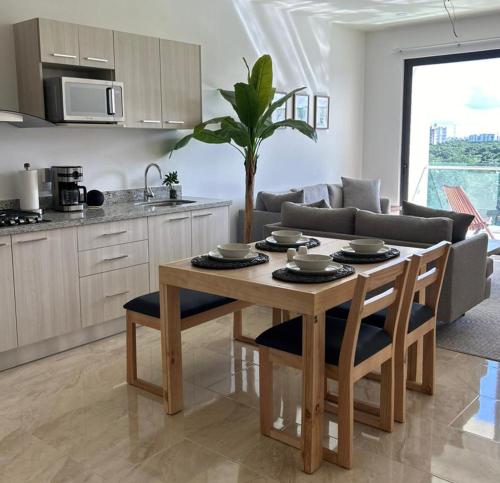 a kitchen and living room with a table and chairs at Depa boutique nuevo de 2 recámaras - diseño, confort y excelente ubicación con alberca in Playa del Carmen