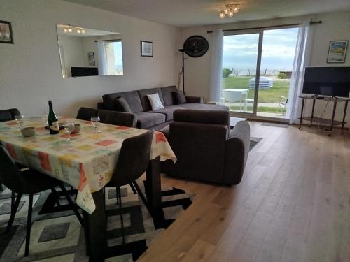 un salon avec une table et un canapé dans l'établissement les Dunes, à Jullouville