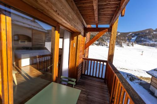 a view from the balcony of a log cabin with a table at Bel appartement 6pers lumineux - Arvieux - Parc naturel du Queyras in Arvieux