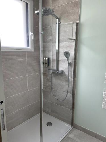 une douche avec une porte vitrée dans une salle de bain dans l'établissement La Sapinière, à Angoulins-sur-Mer