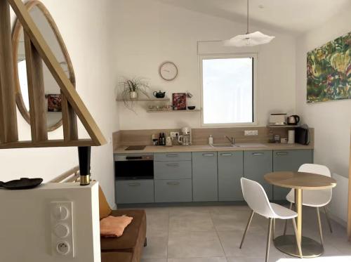 - une cuisine avec une table, une table et des chaises dans l'établissement La Sapinière, à Angoulins-sur-Mer