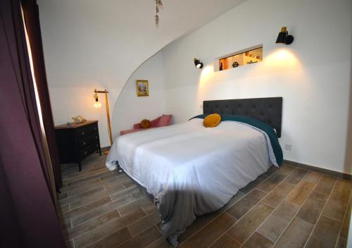 une chambre avec un lit blanc dans une pièce dans l'établissement L'écrin du Pont du Gard, à Remoulins