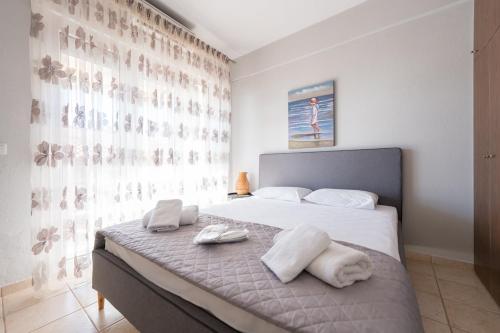 a bedroom with a bed with towels on it at Jella's sunny apartment in Nea Skioni