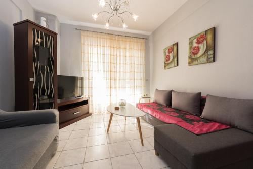 a living room with a couch and a table at Jella's sunny apartment in Nea Skioni