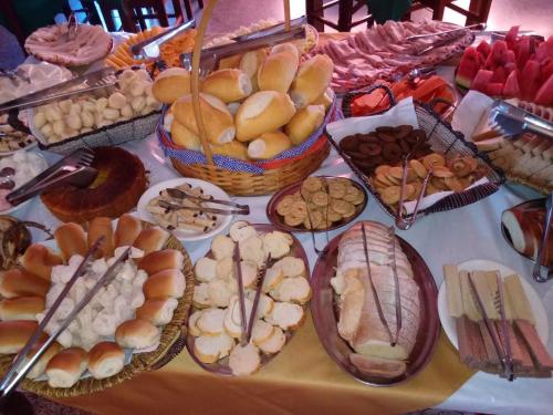 a table full of different types of bread and pastries at Pousada Hotel Chale Parque Aquatico Lindoia in Lindóia