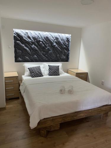 a bedroom with a large white bed with two pillows at Vino & Vista in Ripanj
