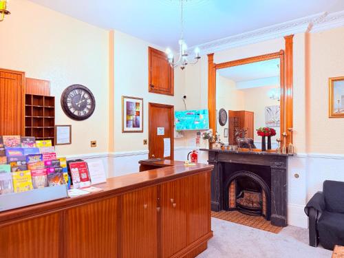 Cette chambre dispose d'un comptoir avec une cheminée et une horloge. dans l'établissement Europa House Hotel, London Paddington, à Londres
