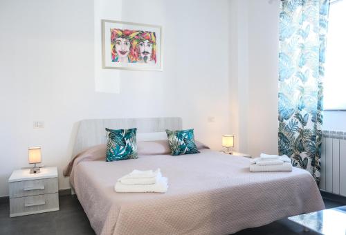 une chambre blanche avec un lit avec des serviettes dessus dans l'établissement Maddareti trilo, à Milazzo