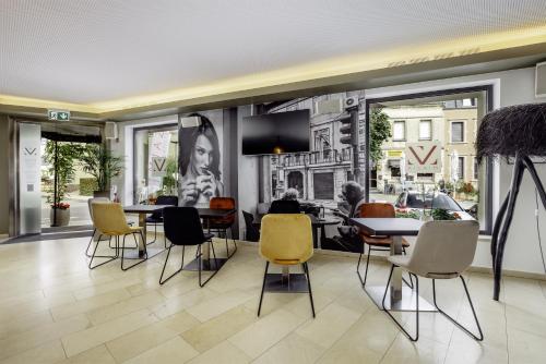 a living room with chairs and a dining room at Hotel Mia Zia in Belvaux