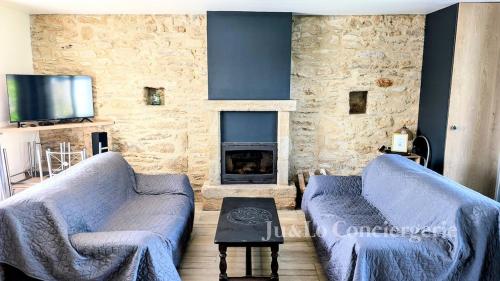 un salon avec deux canapés et une cheminée dans l'établissement Gîte confortable 12 pers à 15 minutes des plages, à Péaule