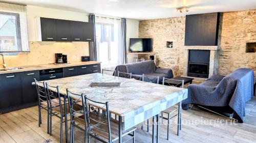 une cuisine avec une table et des chaises dans une pièce dans l'établissement Gîte confortable 12 pers à 15 minutes des plages, à Péaule