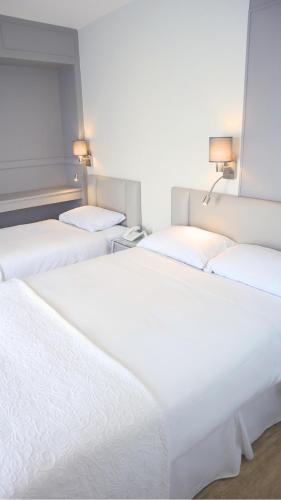 a row of three beds in a room at Centennial Hotel in Cambridge