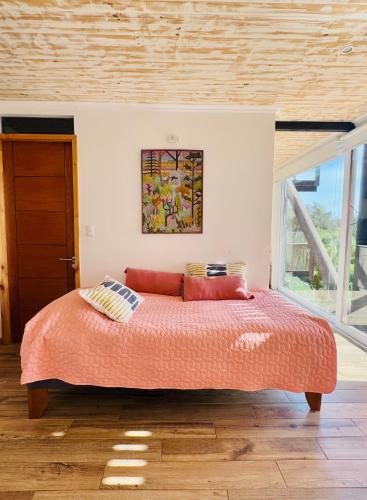 a bedroom with a bed with orange sheets and pillows at Lofts - Casa El Pangue, Zapallar in Zapallar