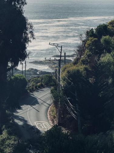 a winding road with a view of the ocean at Lofts - Casa El Pangue, Zapallar in Zapallar