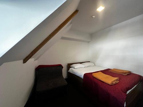 a small room with a bed and a chair at Konaci 25 Kopaonik in Kopaonik