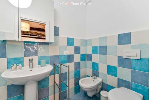 a blue and white bathroom with a sink and a toilet at Cà dei Ciuà, Terre Marine in Riomaggiore