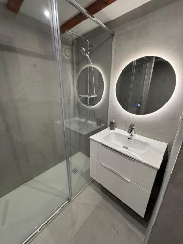 une salle de bain blanche avec un lavabo et un miroir dans l'établissement Maison de la mer, à Hendaye