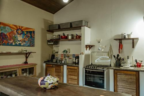a kitchen with a table and a stove top oven at Espaço CurAmar - Praia de Itamambuca in Ubatuba