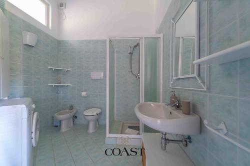 Un baño con lavabo, inodoro y ducha. en Mare & Tranquillità - Trilocale con Wi-Fi, en Olbia