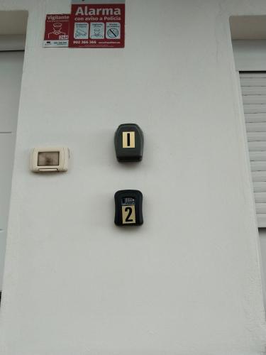a wall with two clocks on a white wall at Los Eucaliptos in Fasnia