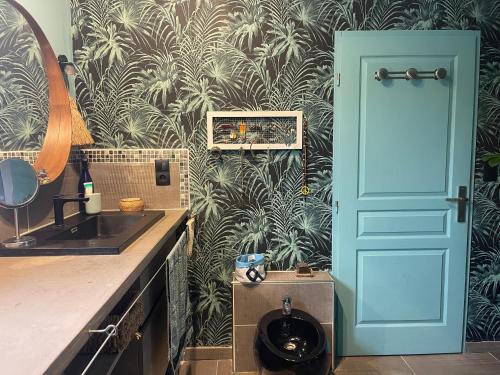 La salle de bains est pourvue d'un lavabo et d'une porte bleue. dans l'établissement Jolie villa avec piscine et vue panoramique sur le golf, à La Grande Motte