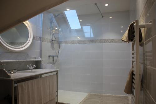 ein Bad mit einer Dusche, einem Waschbecken und einem Spiegel in der Unterkunft Ferme de Canny in Canny-sur-Matz