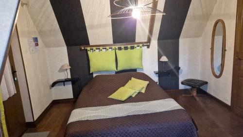 - une chambre avec un lit doté d'un oreiller jaune dans l'établissement La mare aux canards, à Sassetot-le-Mauconduit