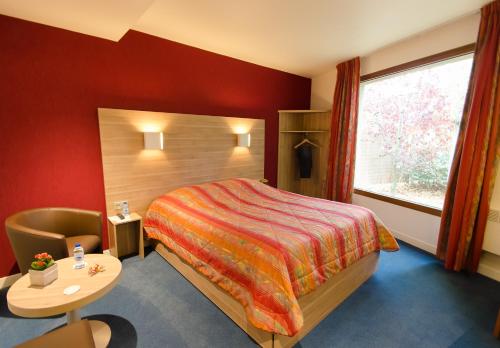 ファッシュ・トゥメニルにあるホテル アジェナのベッド、テーブル、窓が備わる客室です。