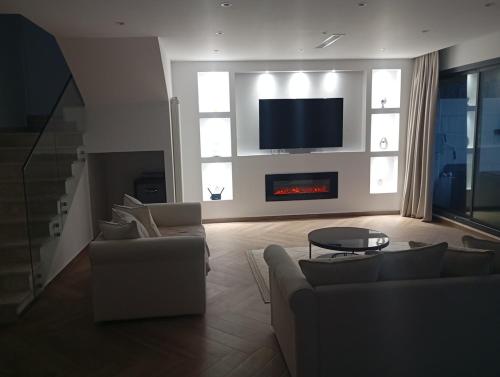 a living room with two couches and a tv at Villa haut standing avec piscine chauffée sans vis-à-vis et hammam in Ouled Moussa