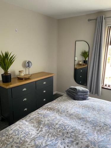 a bedroom with a bed and a dresser and a mirror at Seacoast View in Limavady