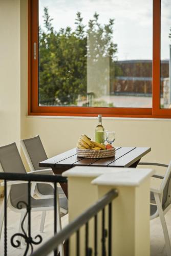 a table with a basket of fruit and a window at Liakoto Villa with private pool and jacuzzi in Makry Gialos