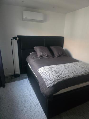 une chambre avec un lit avec une tête de lit noire dans l'établissement Le belle vu appartement T2 65m2, à Le Pont-de-Claix