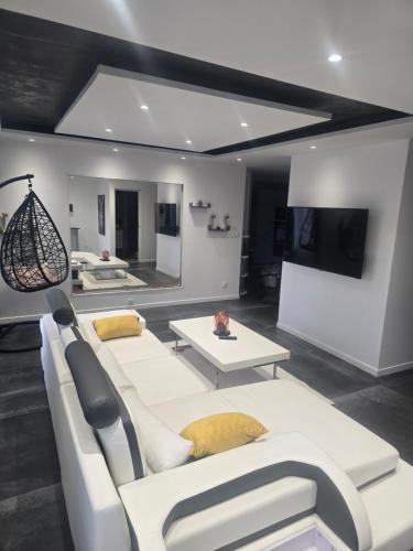 un salon avec un canapé blanc et une télévision dans l'établissement Le belle vu appartement T2 65m2, à Le Pont-de-Claix