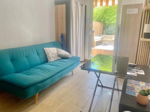 un salon avec un canapé bleu et une table dans l'établissement Studio cosy, terrasse, parking à Carnolès, à Menton