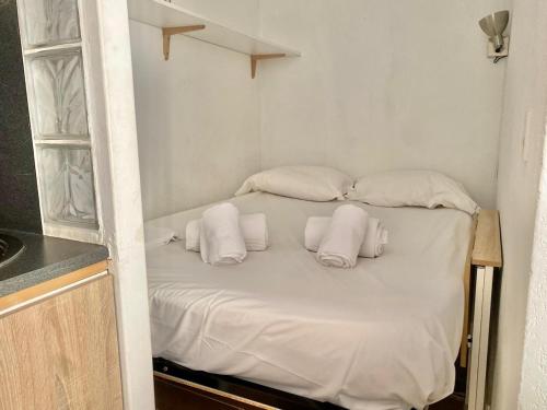 Ce lit se trouve dans un dortoir doté d'oreillers blancs. dans l'établissement Studio cosy, terrasse, parking à Carnolès, à Menton