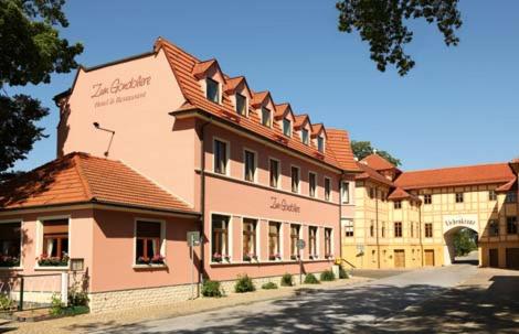 un grand bâtiment rose avec un toit rouge dans l'établissement Hotel Zum Gondoliere, à Oranienbaum-Wörlitz