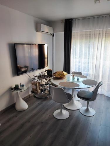 - un salon avec une table, des chaises et une télévision dans l'établissement Studio 31 m², à Nice