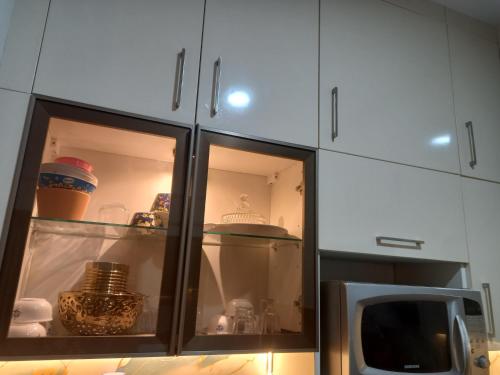 a kitchen with white cabinets and a microwave at Stay comfort at City Heart 2Bhk AC ,WIFI & Much more in Indore