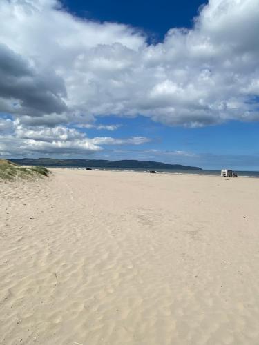 a sandy beach with a blue sky and clouds at Seacoast View in Limavady